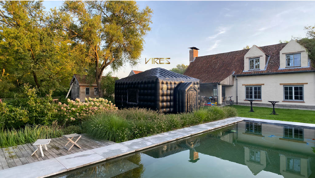 Picture of the VIRES inflatable nightclub tent in a garden next to a pool in front of a house.