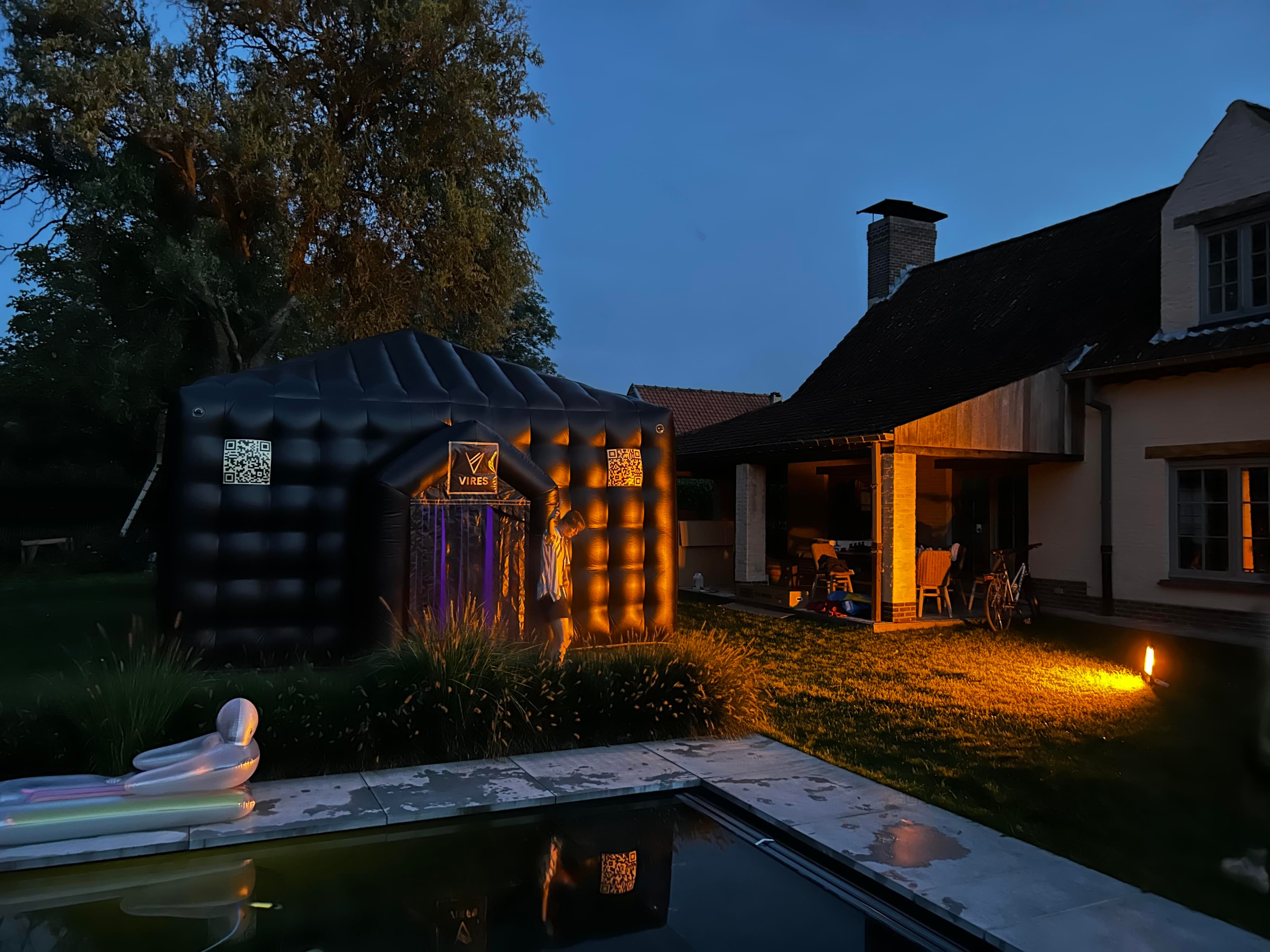 A picture showing the VIRES tent during the evening in a backyard.